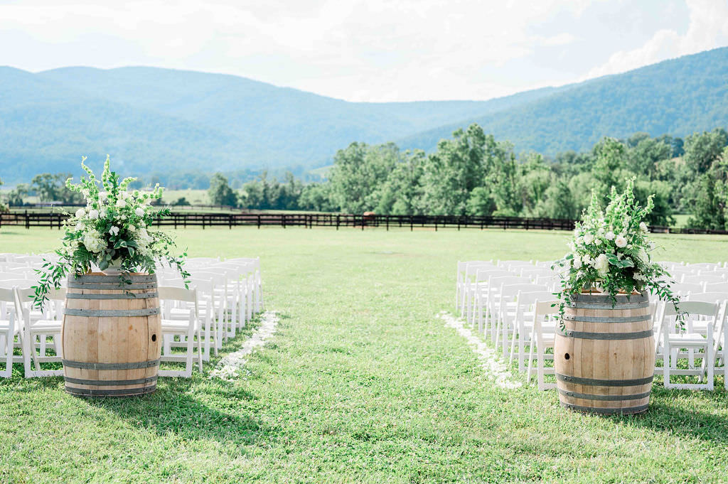 White chairs set up in a field for a wedding at one of the best wedding venues in Charlottesville VA.
