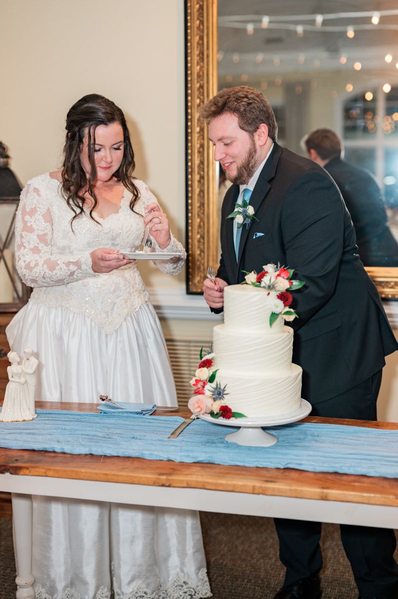 a couple at their wedding reception cutting cake together