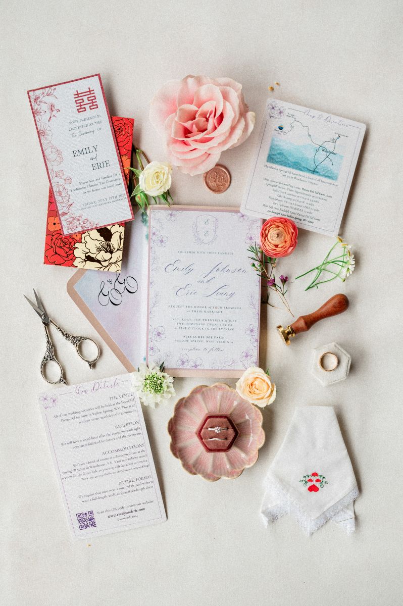 a flat lay of wedding details including flowers, rings, and wedding invitations
