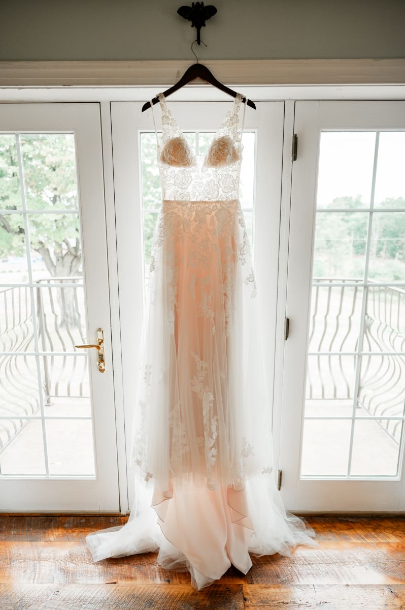 a wedding dress having on a hanger next to a door