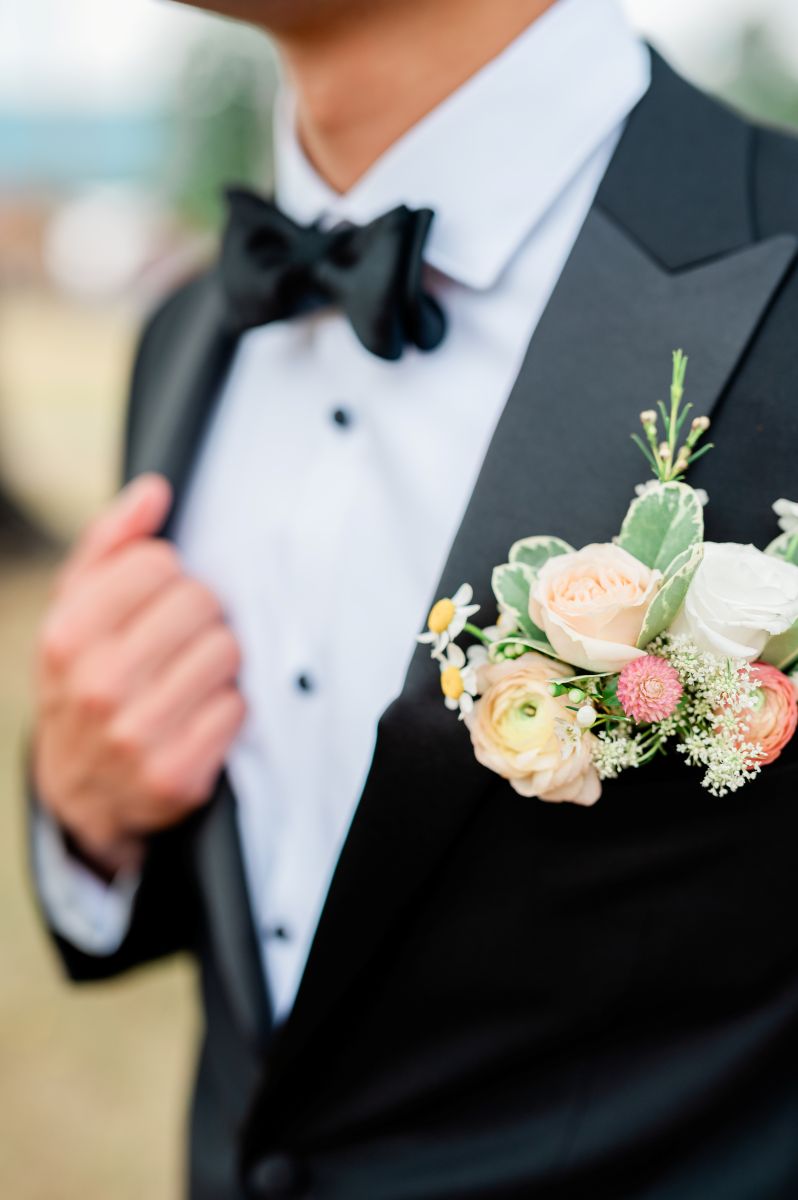 a man wearing a black suit and a floral boutonniere